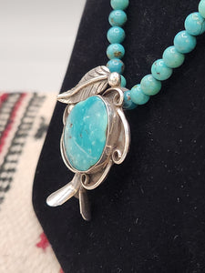 TURQUOISE SQUASH BLOSSOM PENDANT ON TURQUOISE BEADS