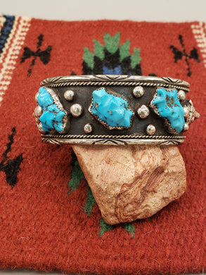 STUNNING NAVAJO HEAVY MEN'S SIZE TURQUOISE BEAR CUFF BRACELET.

Metal - Sterling Silver 

Wrist Size -  fits a 7.75 inch wrist, and has a 1 9/16 inch gap

Width -  1.25 inches wide 

Overall Weight - 102 g  

Main Gemstone - 3 Carved KingmanTurquoise

NAVAJO HANDCRAFTED by artist from ALL TRIBES MANUFACTURERS 

FEATURES BEAR FACE ON EACH END

